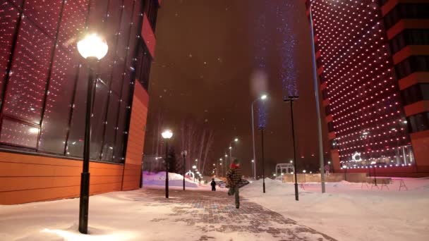 Crianças correndo para a câmera perto do moderno edifício alto à noite no inverno . — Vídeo de Stock