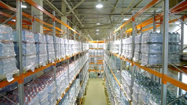 Camera cranes down on shelves of bottled pure water inside a storage warehouse. — Stock Video