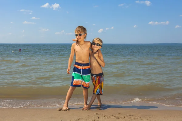 Twee jongens in bril permanent samen op het strand — Stockfoto