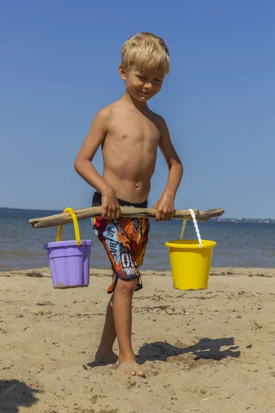快乐男孩玩耍着水桶在沙滩上 — 图库照片