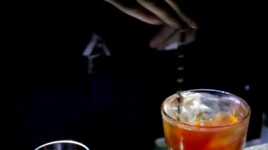 Barmen bir kokteyl ile buz ve limon karışımı