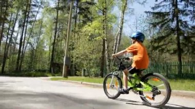 küçük çocuk baharda kask içinde bir Bisiklete binmek