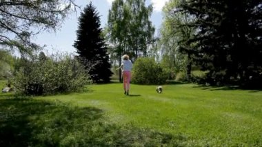 genç kadın parkta köpek pekingese ile çalışan.