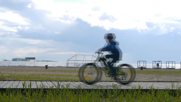 Duas crianças andando de bicicleta bicicletas na praia — Vídeo de Stock