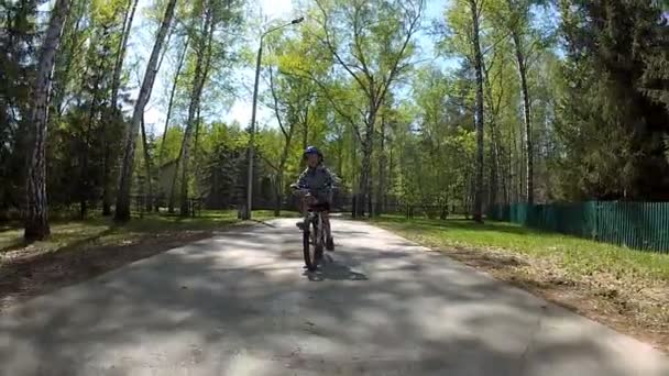 Little boy in helmet cycling on the road in suburbs. — Stock Video