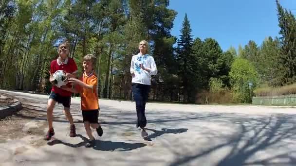 Dos chicos felices con su madre corriendo al aire libre — Vídeos de Stock