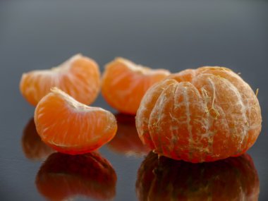 soyulmuş mandalina dilimleri ve bütün mandalina