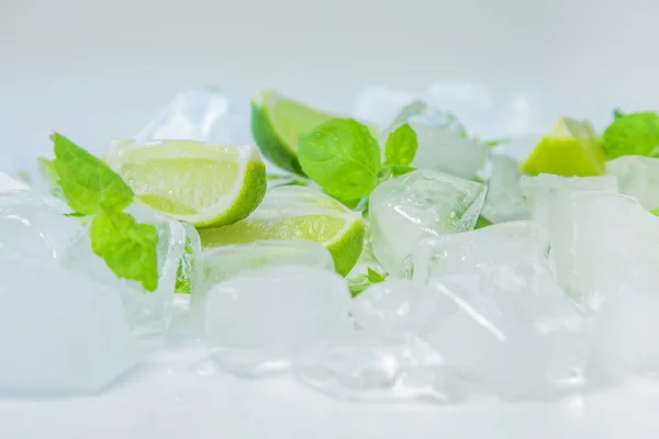 Cubitos de hielo, rodajas de lima y hojas de menta — Foto de Stock