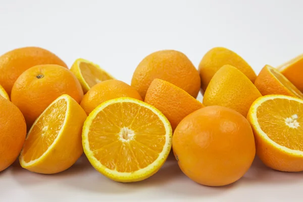 Naranjas enteras y mitades sobre fondo blanco — Foto de Stock