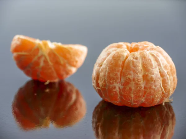Oloupané mandarinky na černém zrcadlový povrch — Stock fotografie