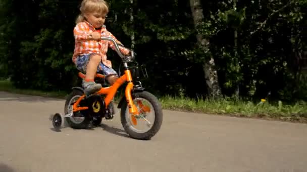 Pequeño niño montar en bicicleta — Vídeo de stock