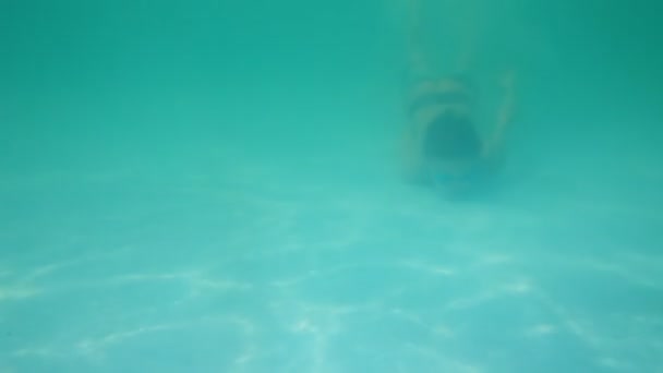 Young boy in googles swimming underwater in pool — Stock Video