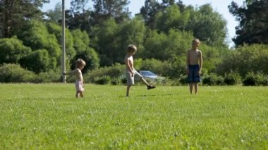 Yeşil çimenlerin üzerinde çalışan üç küçük çocuk çocuklar