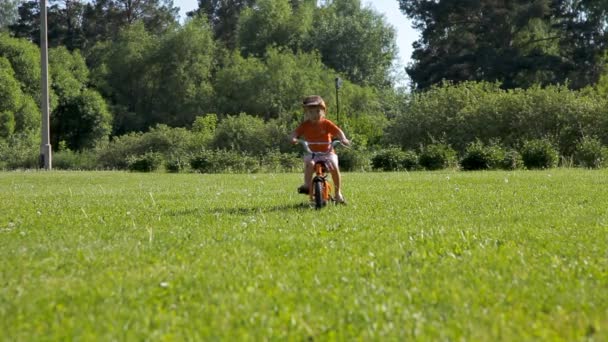 小さな男の子が乗っている自転車、彼の兄は、アクロバティックな車輪. — ストック動画