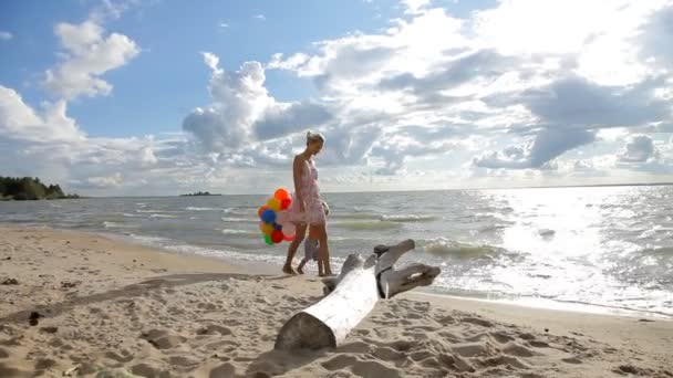 Jonge vrouw met haar zoon wandelen langs de kust — Stockvideo