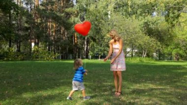 küçük çocuk ona bir balon kalp vermek için anne gider
