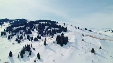 Sersemletici Kış Manzarası 'ndaki Karlı Dağların Üzerindeki Hava Aracı Yolculuğu. Güneşli bir günde yumuşak ışık zirveleriyle Tian Shan dağlarının nefes kesici manzarası. Karkara, Kırgızistan.