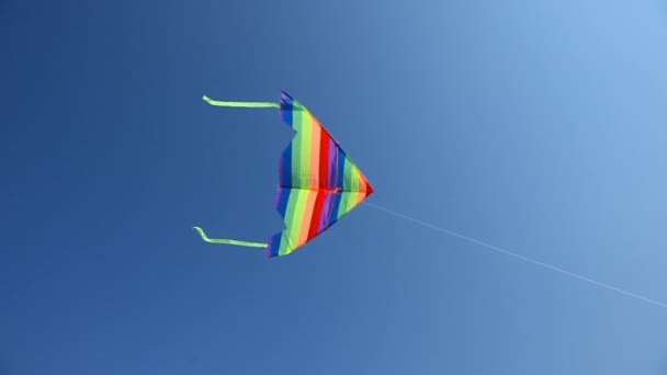 cerf-volant rayé coloré volant dans le ciel bleu 