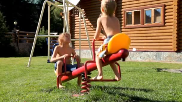Crianças brincando no playground perto de casa — Vídeo de Stock