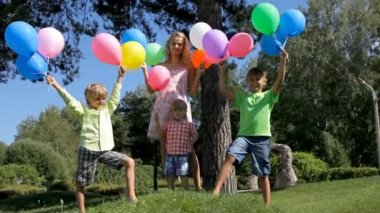 Yeşil park renkli balonlar ile mutlu aile.
