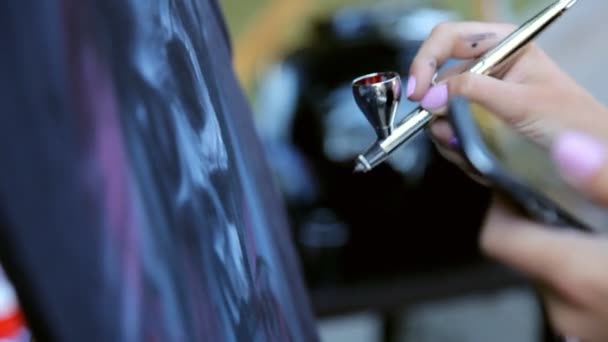 Девушка рисует автомобиль с аэрографом крупным планом — стоковое видео