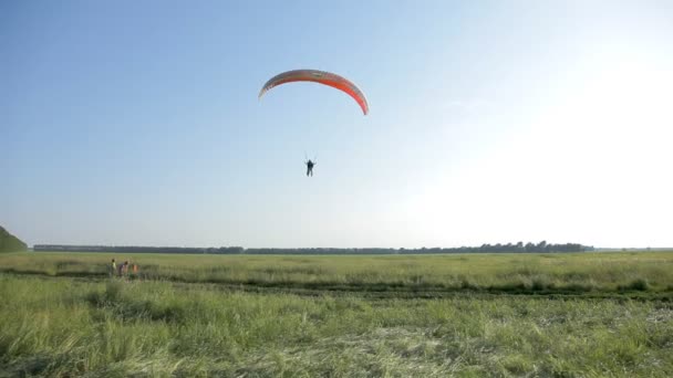 Parapente em conjunto com um instrutor sobre o campo . — Vídeo de Stock