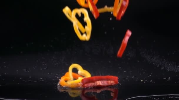 Szeletelt paprika zuhan a víz csobbanásai lassítva. — Stock videók