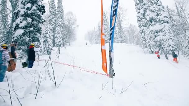 Sciatore che scende lungo la pista da sci con la neve alla deriva in una gara di sci — Video Stock