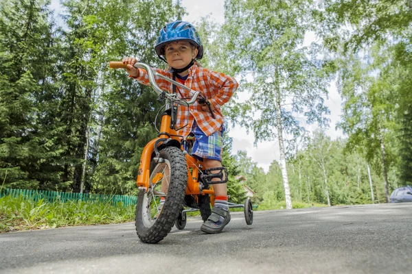 Niño en un casco azul en su bicicleta — Foto de Stock