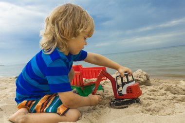 küçük çocuk çocuk oynamak oyuncak tarak ile sahilde