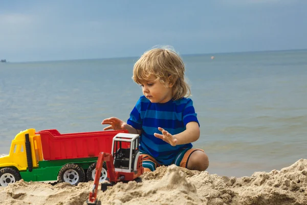 Bambino piccolo ragazzo giocare con giocattoli su il spiaggia — Foto Stock
