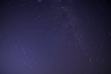 Kutup Yıldızı 'nın etrafında gece gökyüzünde yıldız izleri.