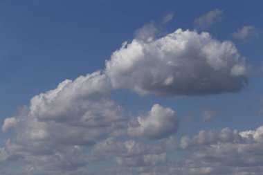 Mavi gökyüzündeki kabarık bulutlara bak