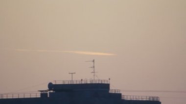 Bolide izlemek alacakaranlıkta gri gökyüzü, beyaz kuyruk çatı siluet arka bina