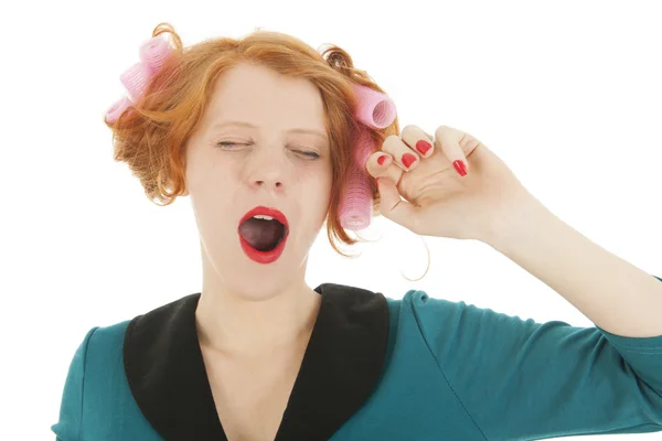 Woman with curlers in hair yawning — Stock Photo, Image