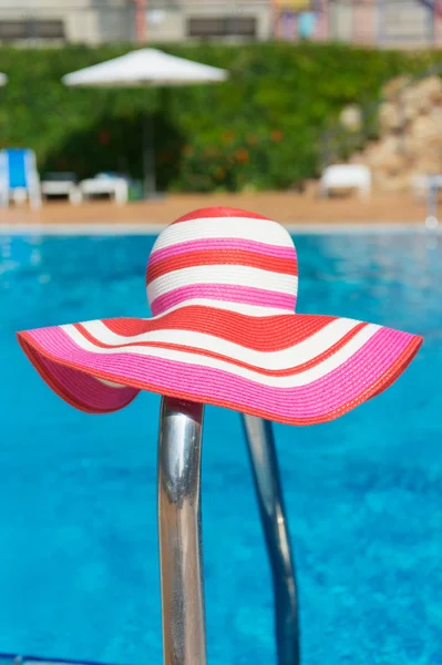 Růžový klobouku proti slunci seběhla u bazénu — Stock fotografie