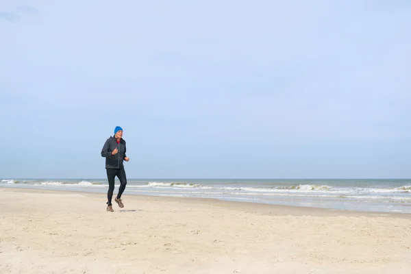 Senior man loopt op strand — Stockfoto