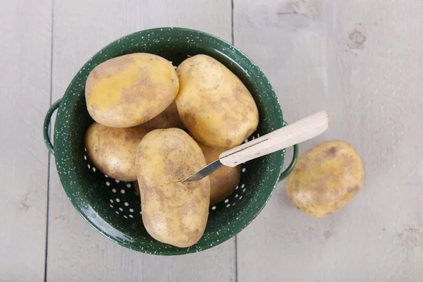 Peeling potatoes with knife — Stock Photo, Image