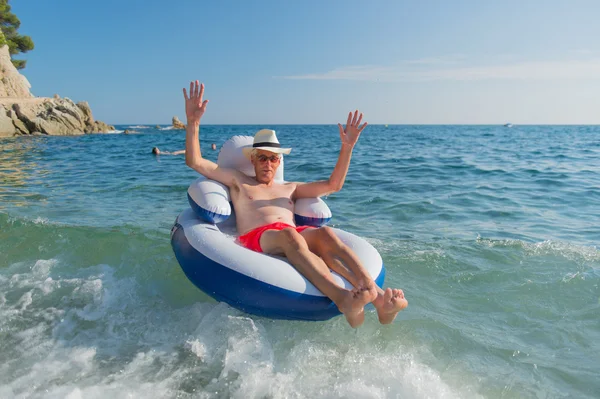 Senior man drijvend in zee — Stockfoto