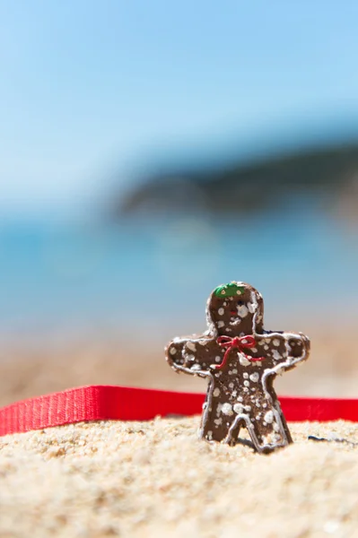 Natal homem de pão de gengibre chocolate na praia — Fotografia de Stock