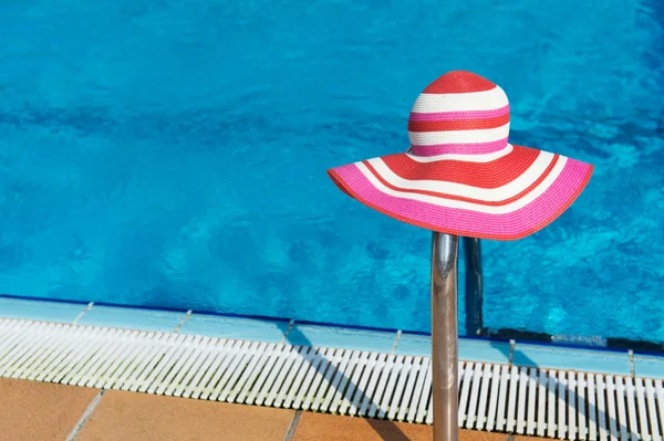 Roze sunhat bij zwembad — Stockfoto