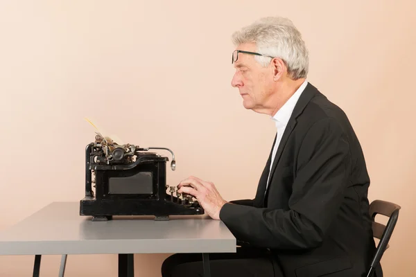 アンティークのタイプライターと年配の男性 — ストック写真