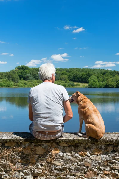 Senior man met oude hond in natuur landschap — Stockfoto