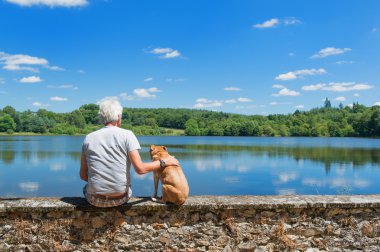 Senior man with old dog in nature landscape clipart