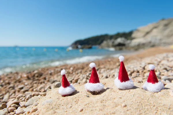 Hattar av Santa Claus på stranden — Stockfoto