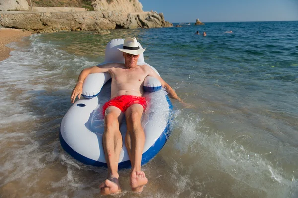 Uomo anziano galleggiante in mare — Foto Stock