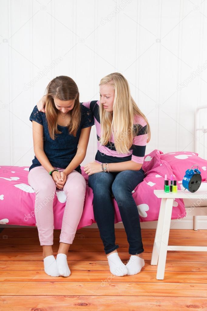 Teenager girl with grief sitting on bed