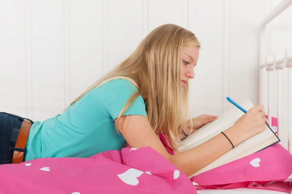 Making homework laying at bed — Stock Photo, Image