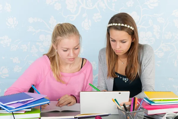 Two teen girls making homework together with digital tablet — Stock Photo, Image