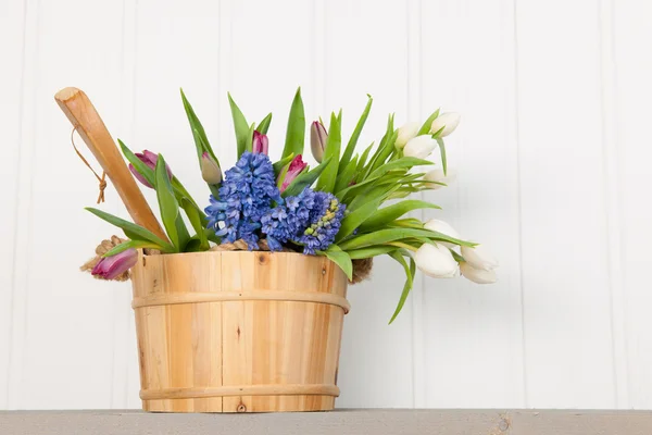 Барвисті букетні весняні квіти в дерев'яному відрі — стокове фото